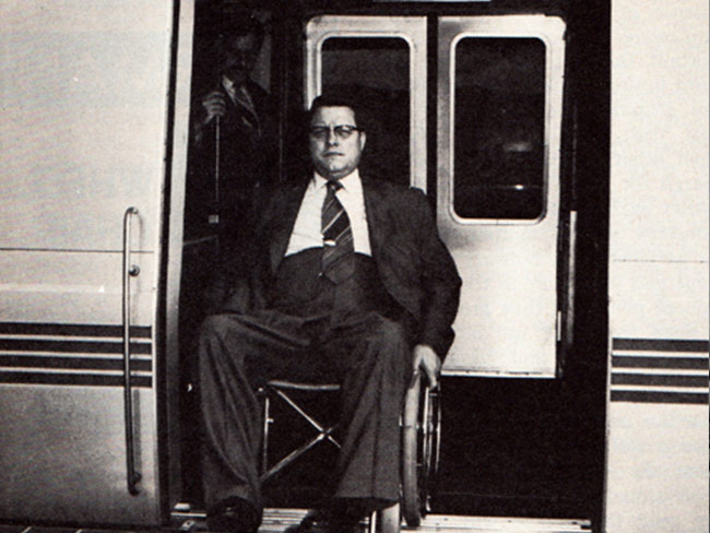 man in wheelchair exiting train