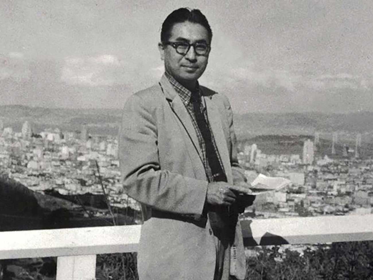 Dr. Isamu Nieda standing with a city view in the background