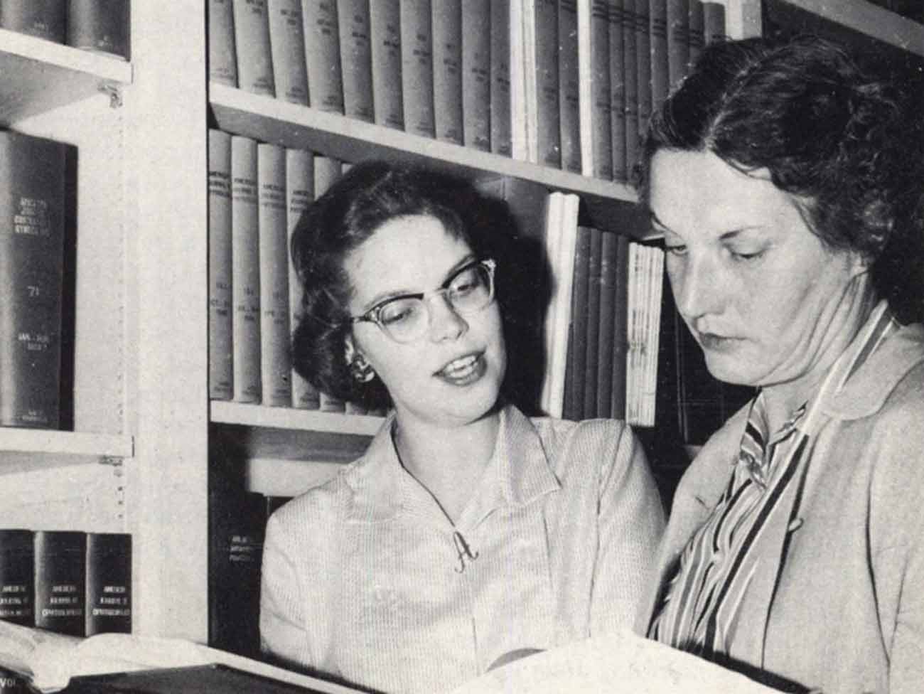 2 librarians looking at a book