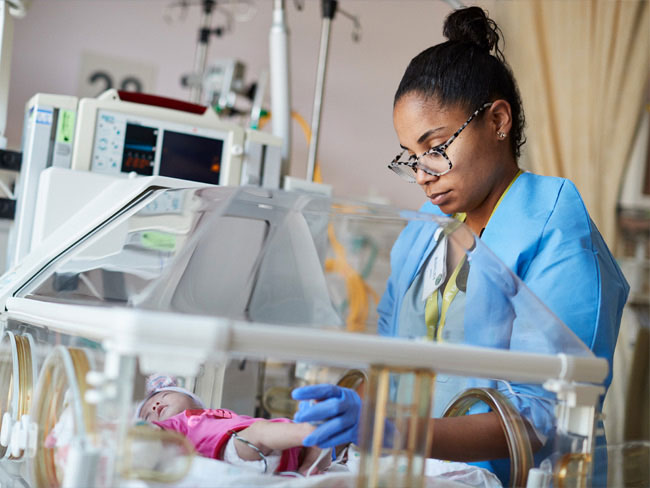 Nurse tending to a baby in the NICU