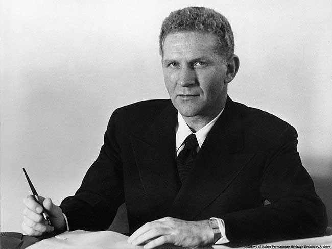 Sidney Garfield, MD sitting at a desk with a pen in hand. 